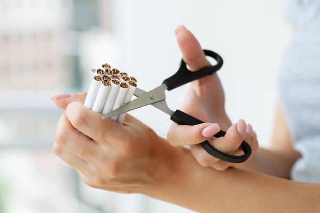 Rzuć palenie kobieta tnie papierosa nożyczkami