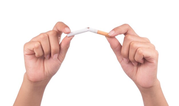 Rzucić palenie, ludzkie ręce łamiące papierosa na białym tle.