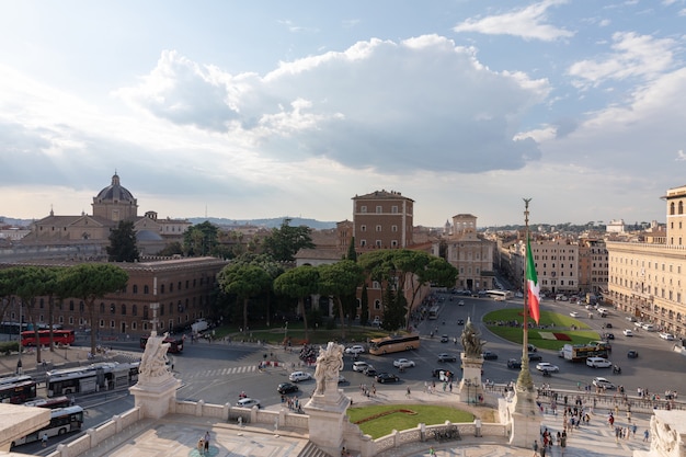 Rzym, Włochy - 19 czerwca 2018: Panoramiczny widok na Piazza Venezia i miasto od pomnika Vittorio Emanuele II, znany również jako Vittoriano w Rzymie. Samochody drogowe i letni dzień z błękitnym niebem