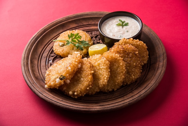 Sabudana Or Sago Vada To Tradycyjna Smażona Przekąska Z Indii. Podawane Z Pikantnym Chutneyem Z Zielonego Lub Orzechowego. Podawaj W Drewnianym Talerzu Na Kolorowym Lub Drewnianym Tle. Selektywne Skupienie