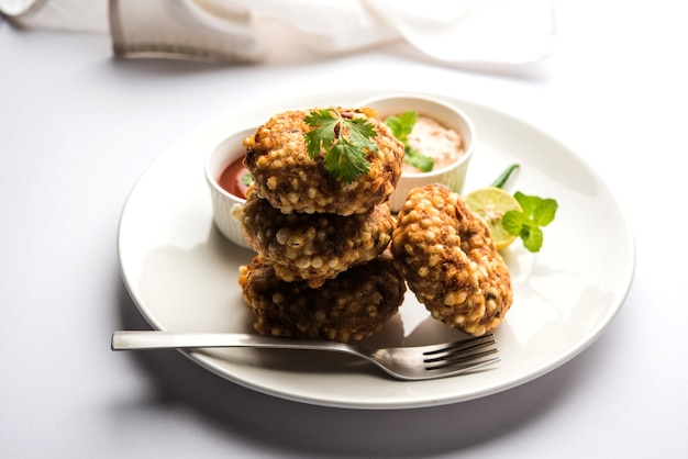 Sabudana Vada Lub Smażone Ciasto Sago Podawane Z Chutneyem Z Orzeszków Ziemnych Na Nastrojowym Tle, Popularny Przepis Na Czczo Z Indii.