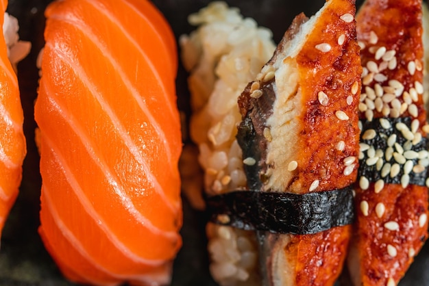 Sake sushi unagi sushi na talerzu do serwowania sushi na ciemnym tle Japońskie jedzenie