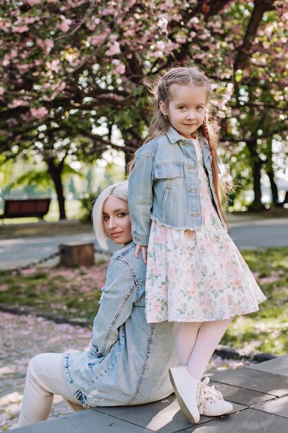 Sakura rozkwitła Młoda mama z dzieckiem bawią się w parku w pobliżu kwitnącej wiśni sakura