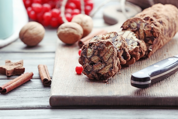 Salami czekoladowe z orzechami włoskimi i czerwonymi jagodami na stole, z bliska