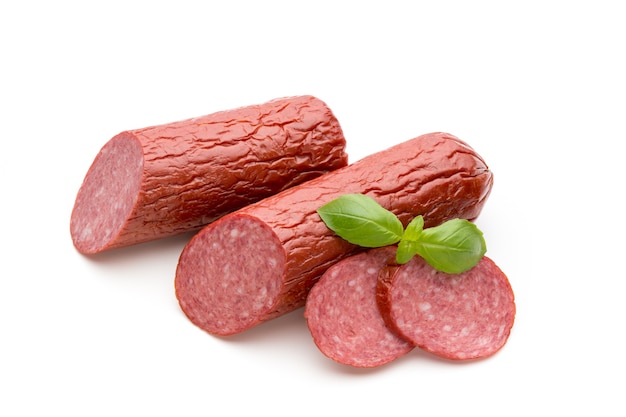 Salami wędzona kiełbasa, liście bazylii na białym tle wyłącznik.