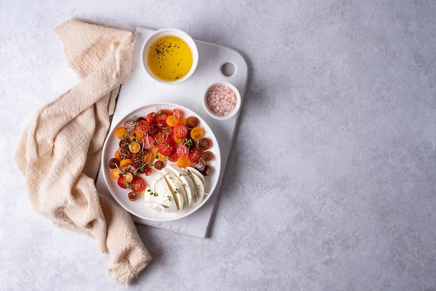 Sałatka Caprese, mozzarella z posiekanymi kolorowymi pomidorkami koktajlowymi.