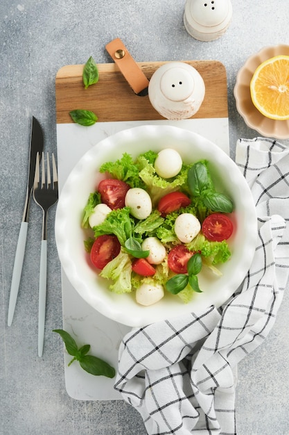 Sałatka caprese Włoska sałatka caprese z plastrami pomidorów ser mozzarella oliwa z bazylii oliwa z oliwek na białym talerzu na białym tle Pyszne włoskie jedzenie Widok z góry Styl rustykalny