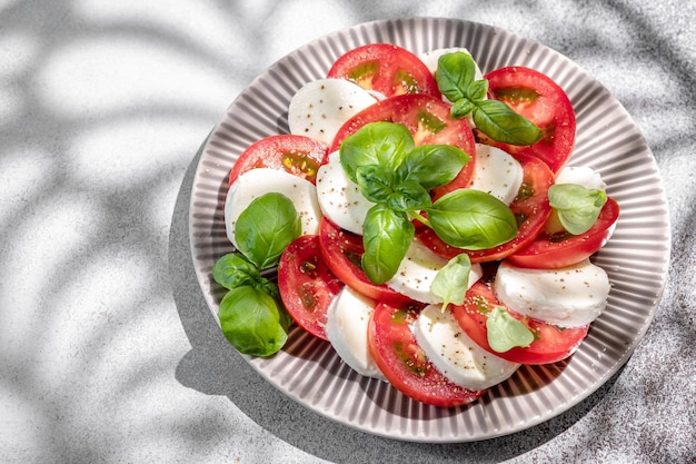 Zdjęcie sałatka caprese z mozzarellą, pokrojonymi pomidorami, przyprawami i świeżą bazylią, domowa koncepcja jedzenia na smaczny i zdrowy posiłek