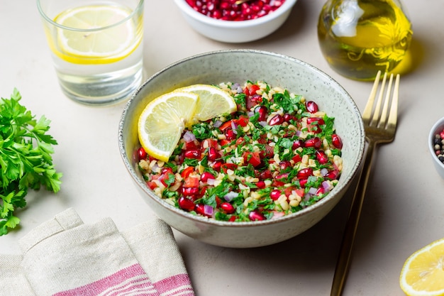 Sałatka Tabbouleh z kaszą bulgur, miętą, pietruszką, pomidorami i granatem. Zdrowe odżywianie. Jedzenie wegetariańskie.