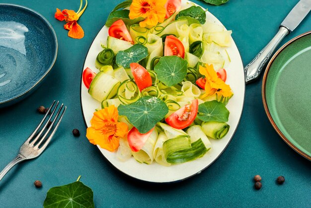 Sałatka witaminowa z różnorodnymi warzywami, liśćmi i kwiatami nasturcji oraz dressingiem