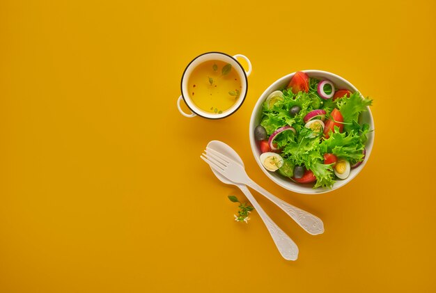 Sałatka ze świeżych warzyw zielonych z sałatą, pomidorami i ogórkiem w misce