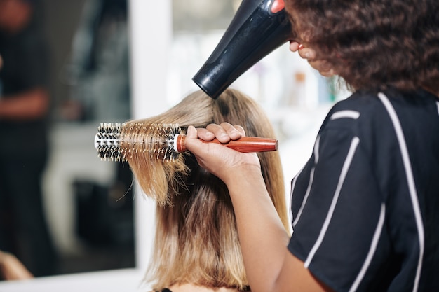 Salon fryzjerski dmuchający włosy klienta