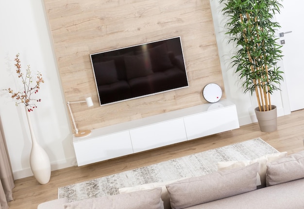 Salon z kanapą i telewizorem led na drewnianej ścianie