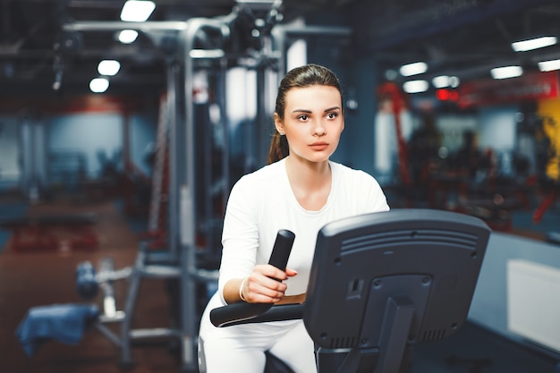 Salowa Kolarstwo Kobieta Robi Cardio Treningowi Jechać Na Rowerze Na Indoors Gym Rowerze.