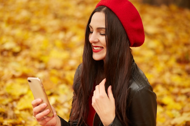 Salowy strzał bierze selfie kobieta przez telefonu komórkowego w spadku kobieta. Jesieni dziewczyna ma smartphone wideo rozmowę.