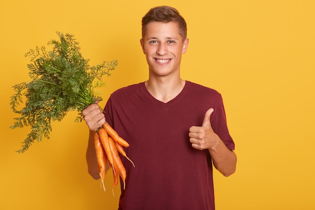 Salowy Strzał Przystojny Mężczyzna Z Wiązką Marchewki Pokazuje Aprobaty