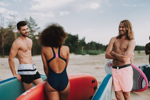 Samce i samice surferów rozmawiających na plaży.