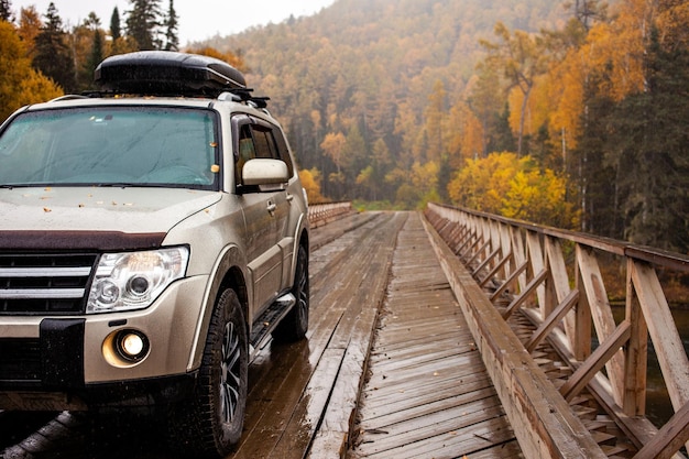 Zdjęcie samochód 4x4 na drewnianym moście w lesie jesienią