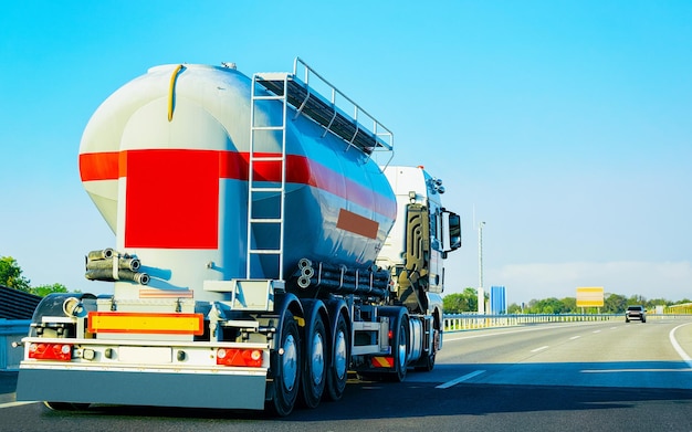 Samochód ciężarowy z magazynem płynów lub olejów na drogach lub autostradach Polski. Samochód ciężarowy z cysterną serwisową przy pracach logistycznych. Cysterna naczepy. Jazda samochodem towarowym. Dostawa ładunku. Branża transportowo-eksportowa