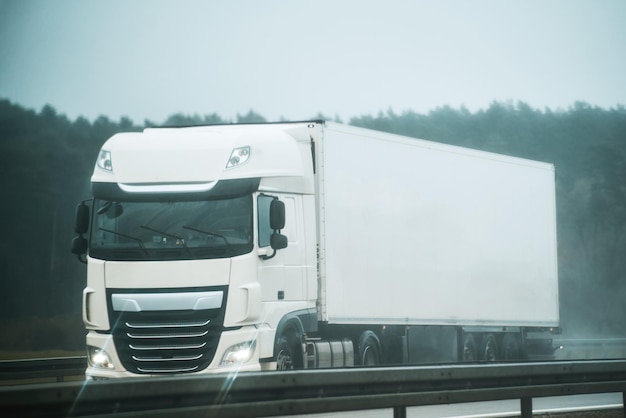 Samochód dostawczy na autostradzie w Europie Naczepa z przyczepą towarową jadąca w tunelu Szybko poruszająca się ciężarówka Kierowca ciężarówki jeździ swoją nowoczesną ciężarówką