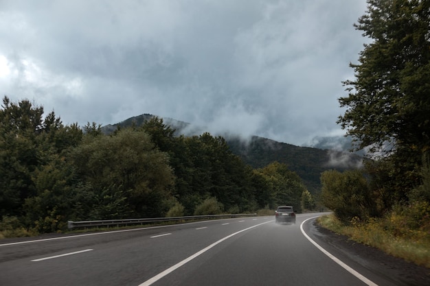 Samochód suv na mokrej drodze w górach piękny krajobraz