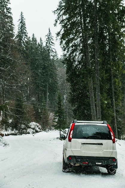 samochód SUV z łańcuchem na kołach w śnieżnym lesie