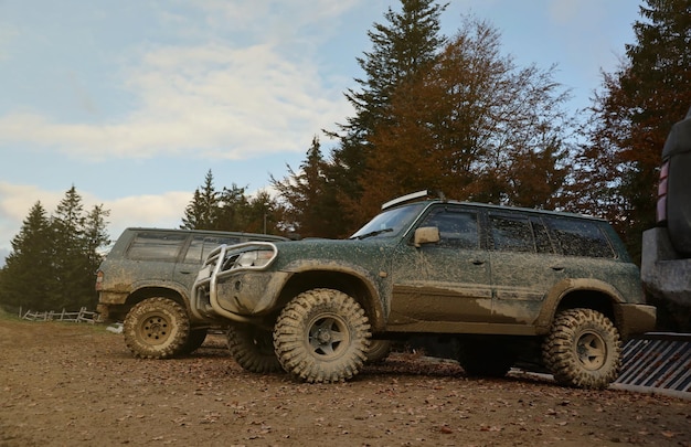 Zdjęcie samochód w krajobrazie wiejskim z błotnistą drogą offroad x samochód suv z kostką