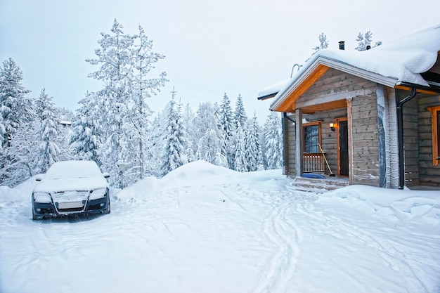 Samochód zaparkowany w drewnianym domku w Ruce w Finlandii na kole bieguna polarnego zimą