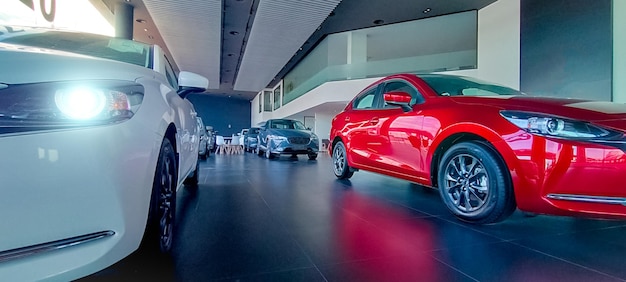 Samochód zaparkowany w luksusowym salonie samochodowym Biuro dealera samochodowego Nowy czerwony samochód zaparkowany w nowoczesnym salonie samochodowym Auto