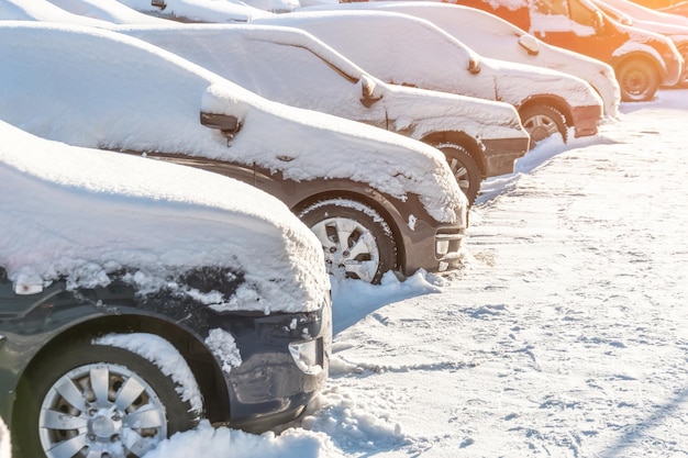 Samochody pokryte śniegiem na parkingu w dzielnicy mieszkalnej