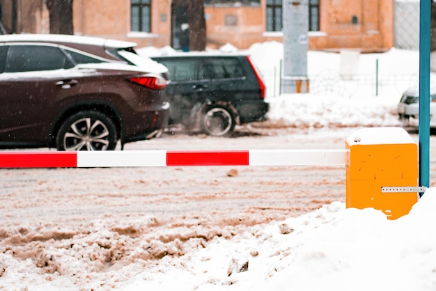 Samochody poruszają się przez zaśnieżone miasto w pobliżu parkingu biało-czerwonego