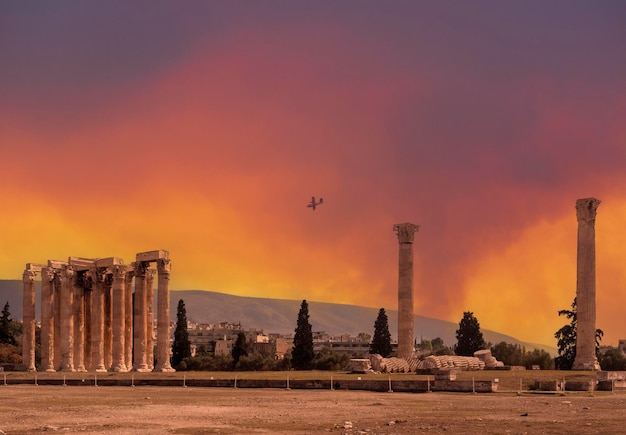 Samolot gasi pożar na tle Zabytkowa marmurowa świątynia Zeusa Olimpijskiego w Atenach, Grecja