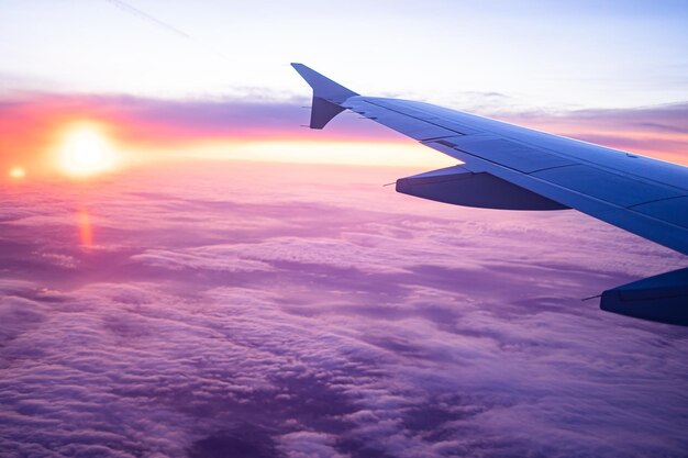 Zdjęcie samolot latający nad chmurami podczas zachodu słońca