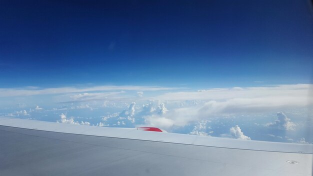 Zdjęcie samolot latający nad krajobrazem na tle niebieskiego nieba