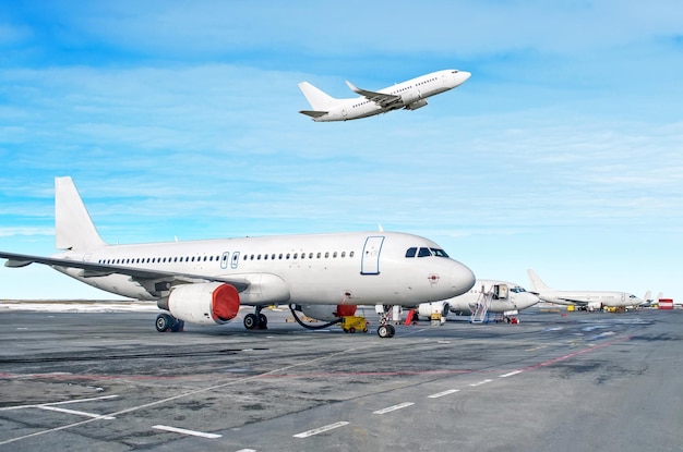 Samolot pasażerski zaparkowany w służbie przed odlotem na lotnisku Jeden samolot startuje na pas startowy na zachmurzonym niebie