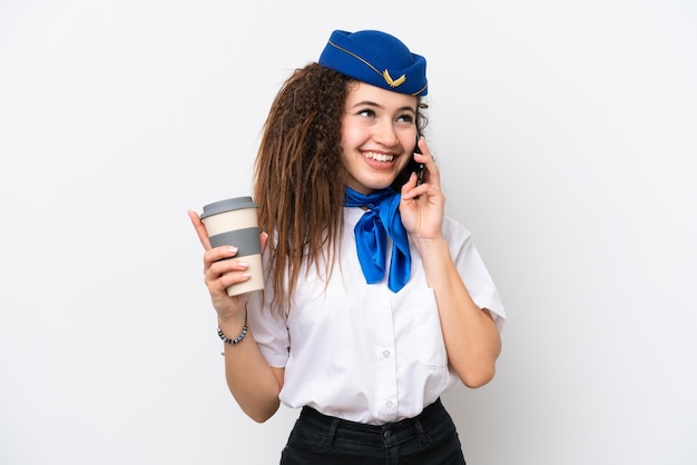 Samolotowa stewardesa Arabska kobieta na białym tle trzymająca kawę na wynos i telefon komórkowy