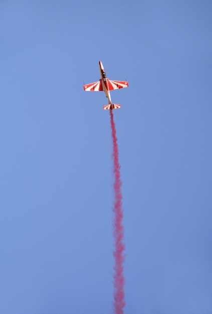 Samoloty wojskowe latają w grupie z dymem na niebieskim niebie