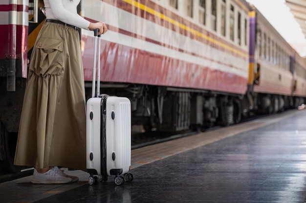 Samotna Azjatka podróżująca z walizką na peronie dworca kolejowego Letnie wakacje wakacje i koncepcja podróży.