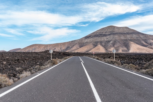 Samotna droga pośrodku pustynnego krajobrazu Lanzarote.