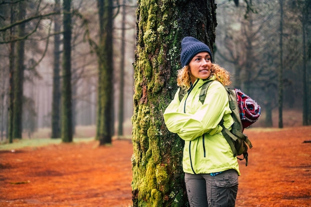 samotna kobieta w zimnych i zimowych ubraniach cieszy się wypoczynkiem na świeżym powietrzu w lesie las z drzewami