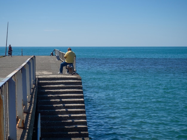 Samotny mężczyzna na molo Odpoczynek nad brzegiem morza Ucieczka od codzienności