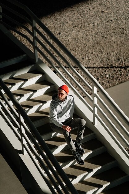 Samotny Młody Człowiek W Okularach Siedzi Sam Na Betonowych Schodach W Budynku Miejskim Lub Przestrzeni Miejskiej Nad Widokiem