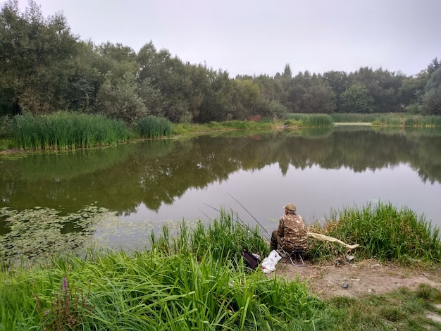 Zdjęcie samotny rybak latem na jeziorze