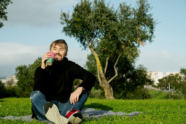 Zdjęcie samotny, samotny, samotny mężczyzna w średnim wieku pijący kawę w parku. pojęcie samotności, dystansu społecznego i samozagłady. koncepcja zdrowia psychicznego, łącząca się z naturą
