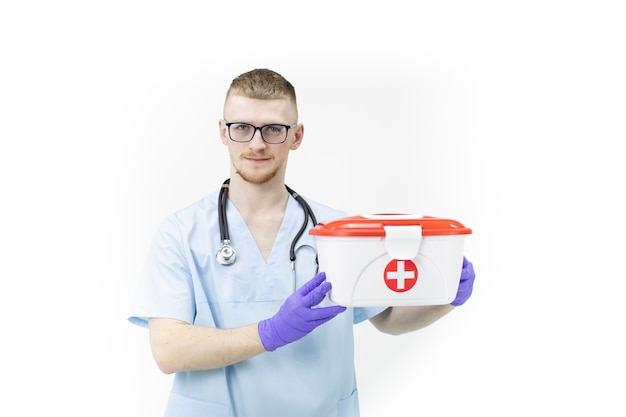 Sanitariusz w szkłach i błękitnych lateksowych rękawiczkach trzyma czerwonego krzyża medycznej skrzynki zakończenie up