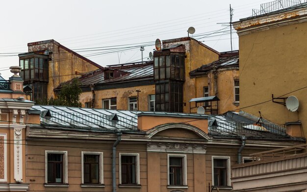 Sankt Petersburg wilgotne dachy starych budynków tynkowanych po deszczu przy pochmurnej pogodzie Zewnętrzny szyb windy w środku ramy