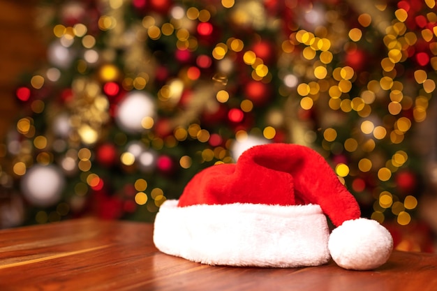 Zdjęcie santa hat na tle ozdobionej choinki. koncepcja bożego narodzenia i nowego roku