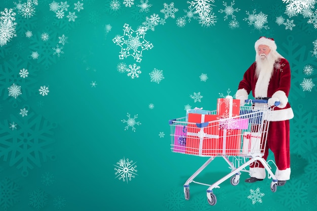 Santa pcha wózek na zakupy z prezentami na tle zielonego płatka śniegu