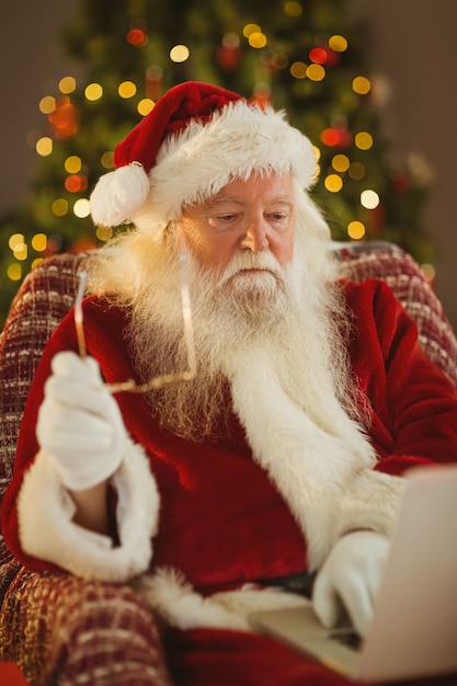 Santa trzyma jego szkła i używa laptop