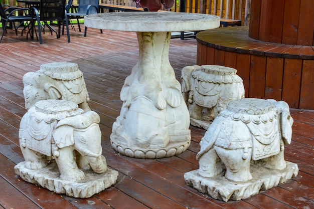 Sanya, Hainan, Chiny - 20 lutego 2020: Kamienny stół ze stołkami w postaci małych słoni na terenie buddyjskiego centrum Nanshan.